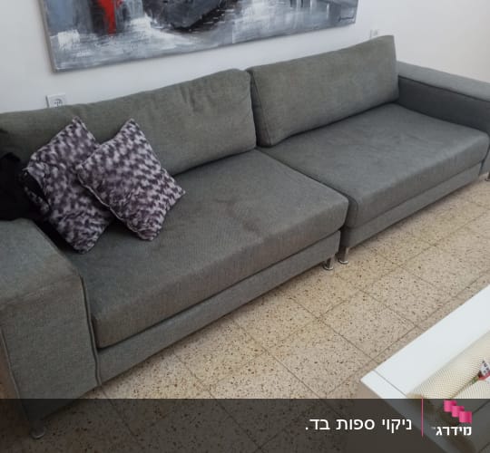 ספה אפורה עם כריות על רצפת אריחים